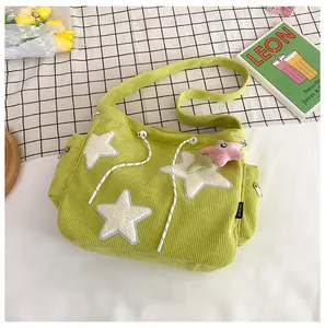 Détail de la texture velours côtelé vert avec étoiles en peluche et fermeture éclair