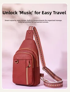Detail of red crossbody bag with patterned strap and functional multi-zipper pockets