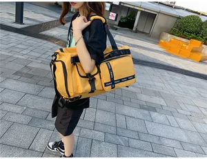 Close-up of yellow travel bag with reinforced straps and multi-pocket waterproof design