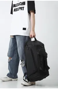 Close-up of a black waterproof nylon gym bag with multiple storage pockets and handles