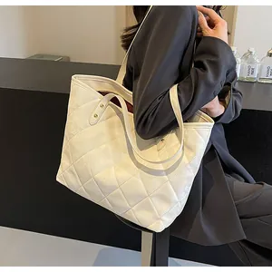 Macro detail of white quilted stitching texture on large minimalist tote bag