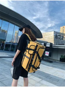 Detail view of a yellow waterproof travel backpack with multiple compartments and buckles
