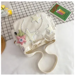 Détail du sac cabas blanc en velours côtelé avec broderie d'étoiles et breloques