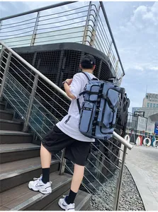 Detail of grey-blue travel backpack showing multi-pocket structure and adjustable side straps