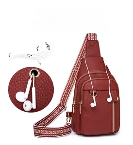Detail of red lychee pattern leather chest bag with golden zippers and earphone port