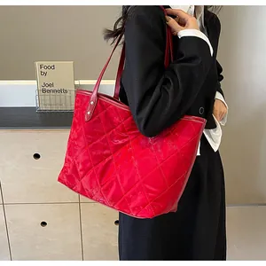 Detailed view of red quilted tote bag with diamond stitching and slim shoulder straps