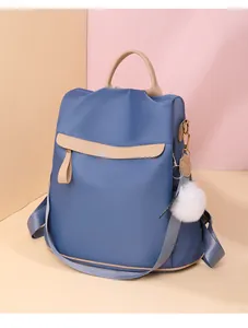 Sac à dos antivol bleu en nylon pour femme avec détails beige et pompon blanc doux