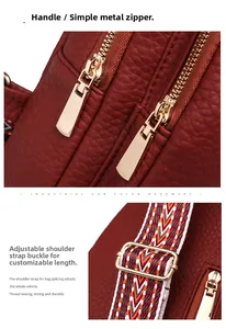 Detail of wine red lychee leather bag with gold hardware and woven crossbody strap