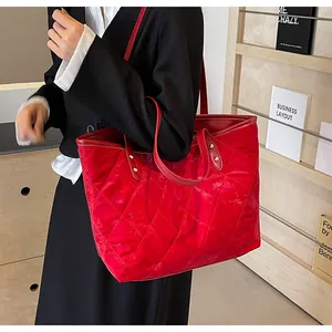 Detail of red quilted tote bag with diamond stitching and elegant gold metal rivets