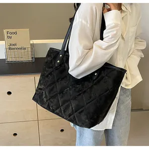 Detail of black quilted tote bag with vintage texture and stylish metal rivet accents