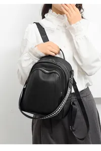 Modello con zaino in pelle nera motivo litchi con cerniera a onde e tracolla fantasia