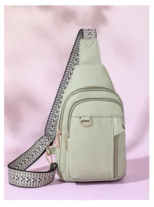Close-up of mint green textured leather crossbody bag with chic woven shoulder strap