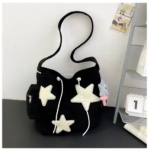 Détail du grand sac cabas en velours côtelé noir avec patchs étoiles et cordon de serrage