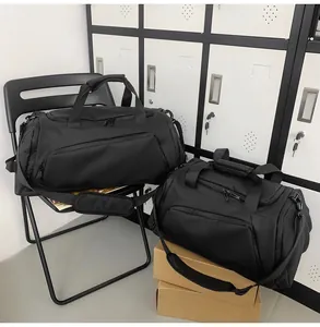 Detailed view of large and small black waterproof sports duffel bags in a gym setting