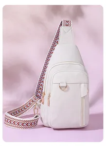 Close-up of white lychee texture leather chest bag with colorful geometric woven strap