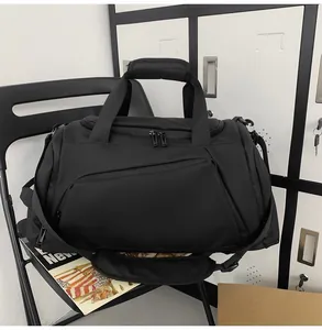 Close-up of black fitness bag with padded handles and adjustable shoulder strap on a chair