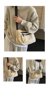 Close-up of beige nylon crossbody bag featuring multi-pocket design and black wide strap