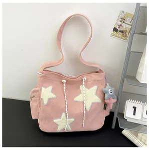 Détails d'un sac cabas en velours côtelé rose avec étoiles en peluche et cordon de serrage