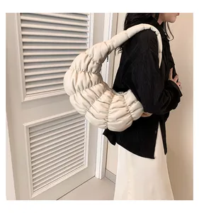 Detail of quilted texture and soft padded handle on this cream white cloud bag