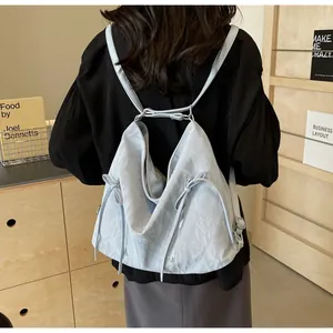 Close-up of a light blue pleated backpack with drawstring detail and side zippers