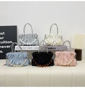 Detail of colorful ruched handbags with rhinestone handles and large beaded accents