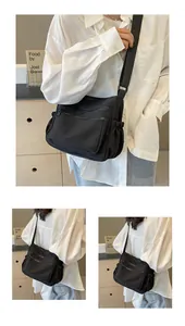 Close-up of black nylon crossbody bag featuring multiple zipper pockets and adjustable strap