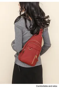 Detail view of a red lychee texture leather chest bag worn by a model in a casual style