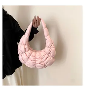Detailed side view of a pink pleated cloud bag featuring quilted nylon and metal zipper