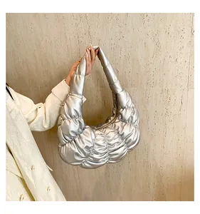 Close-up of metallic silver cloud bag with quilted ruched design and soft texture