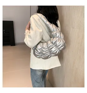 Silver metallic pleated cloud bag worn by model showing trendy ruched hobo design
