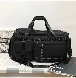 Detail of waterproof black travel bag showing dual handles and adjustable shoulder strap
