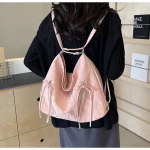 Rear view of model wearing pink nylon tote bag with bow detail and vertical zippers