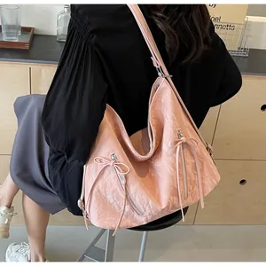 Detailed view of pink tote bag with pleated texture and stylish ribbon bow accents