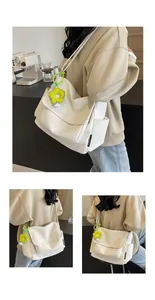 Detail van de gebroken witte canvas schoudertas met een felgroene bloemenhanger