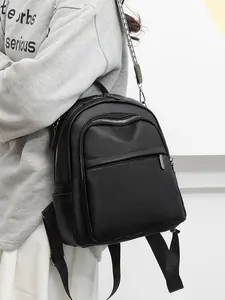 Zaino da donna minimalista in pelle nera con eleganti spalline a pois