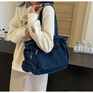 Dettaglio di una grande borsa tote in denim blu scuro con portamonete rotondo abbinato