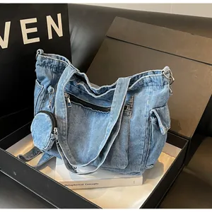 Dettaglio della borsa tote in denim blu con tasche a zip, tasca laterale e portamonete