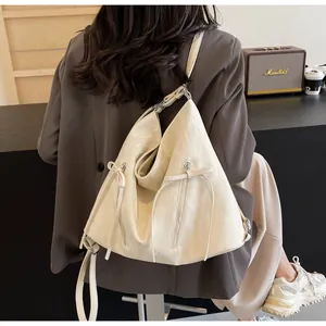 Detailed view of cream PU leather bag with butterfly bow zippers and adjustable strap