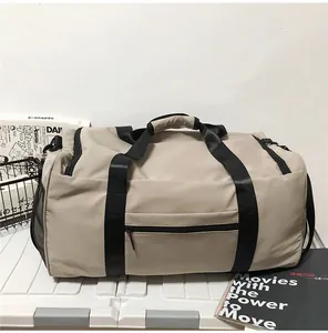 Detail of beige travel bag with black handles and side mesh pocket on white stand