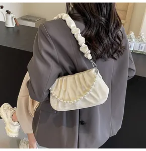 Detail der cremeweißen gerafften Cloud-Tasche mit Perlenkette und Falten-Schultergurt