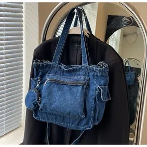 Dettaglio della borsa tote in denim blu con tasche multiple e un piccolo portamonete