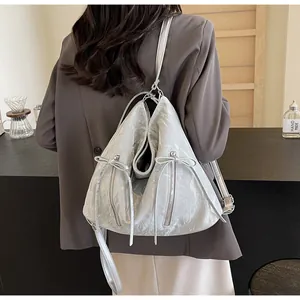 Silver wrinkled leather backpack detail featuring elegant bow zipper accents on side