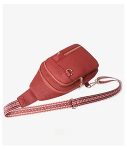 Detail showing red pebble leather texture and geometric patterned wide woven strap