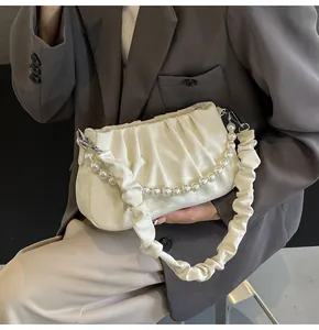 Detailansicht der cremefarbenen Cloud Bag mit Perlenkette und Silberbeschlägen
