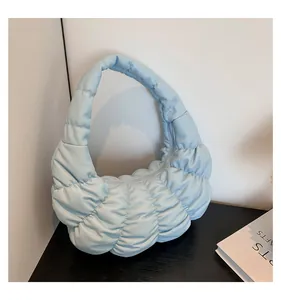 Detailed view of light blue quilted hobo bag featuring soft pleated fabric and zip closure