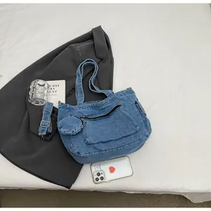 Dettaglio della borsa tote in denim blu con portamonete e tracolla regolabile in set