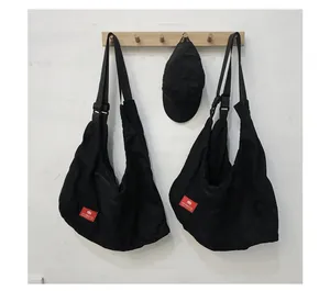 Detail of black cotton crescent bags and baseball cap with red HEYMISTER brand label