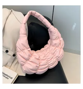 Detailed view of pink quilted cloud bag with pleated leather texture and crescent shape