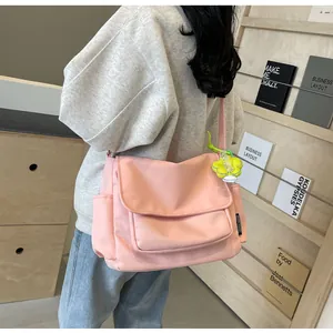 Roze canvas crossbodytas met functionele zijzakken en een bloemvormige tashanger