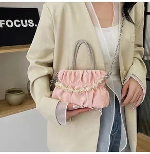 Detail of pink pleated cloud bag with pearl handle and silver metal chain strap